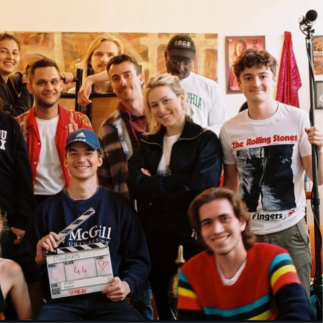 Fellow film crew posing with clapper board