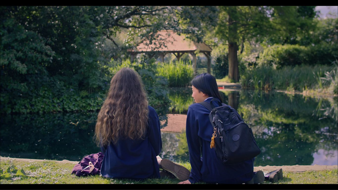 Evergreen stills of two leads sat facing the water and chatting