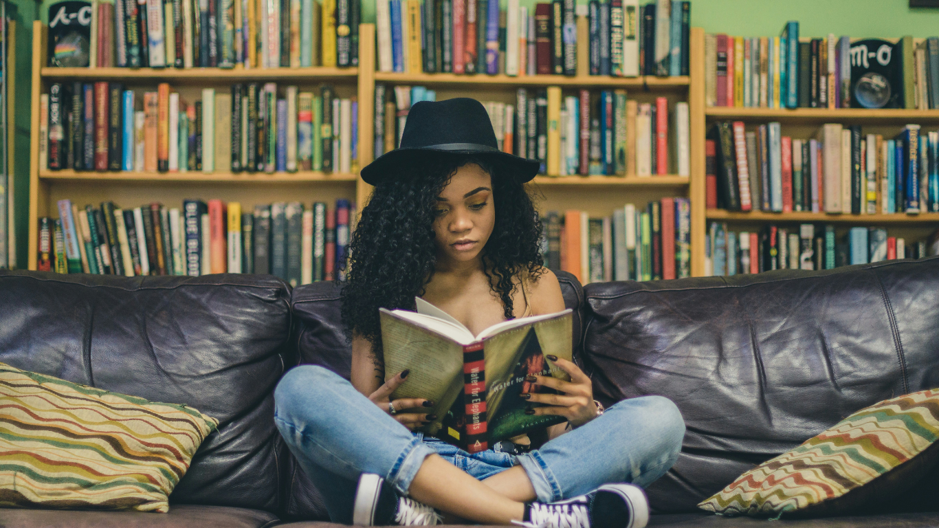 Woman reading a book surrounded by books