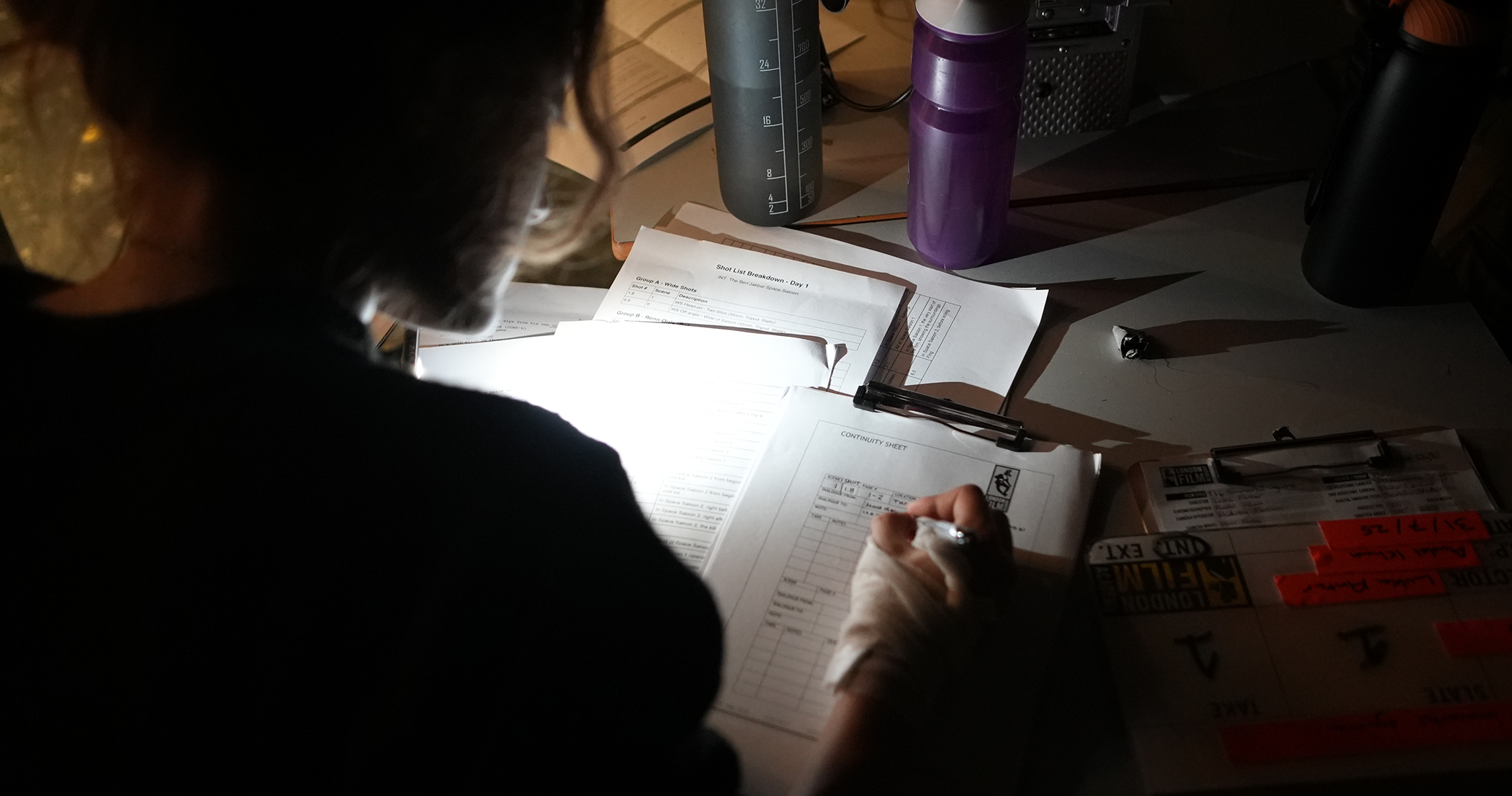Student looking over timetable and budget documents on film set