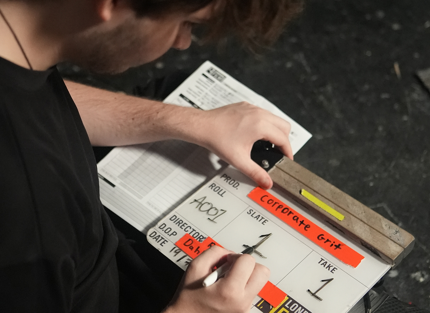 Student writing movie title on clapperboard