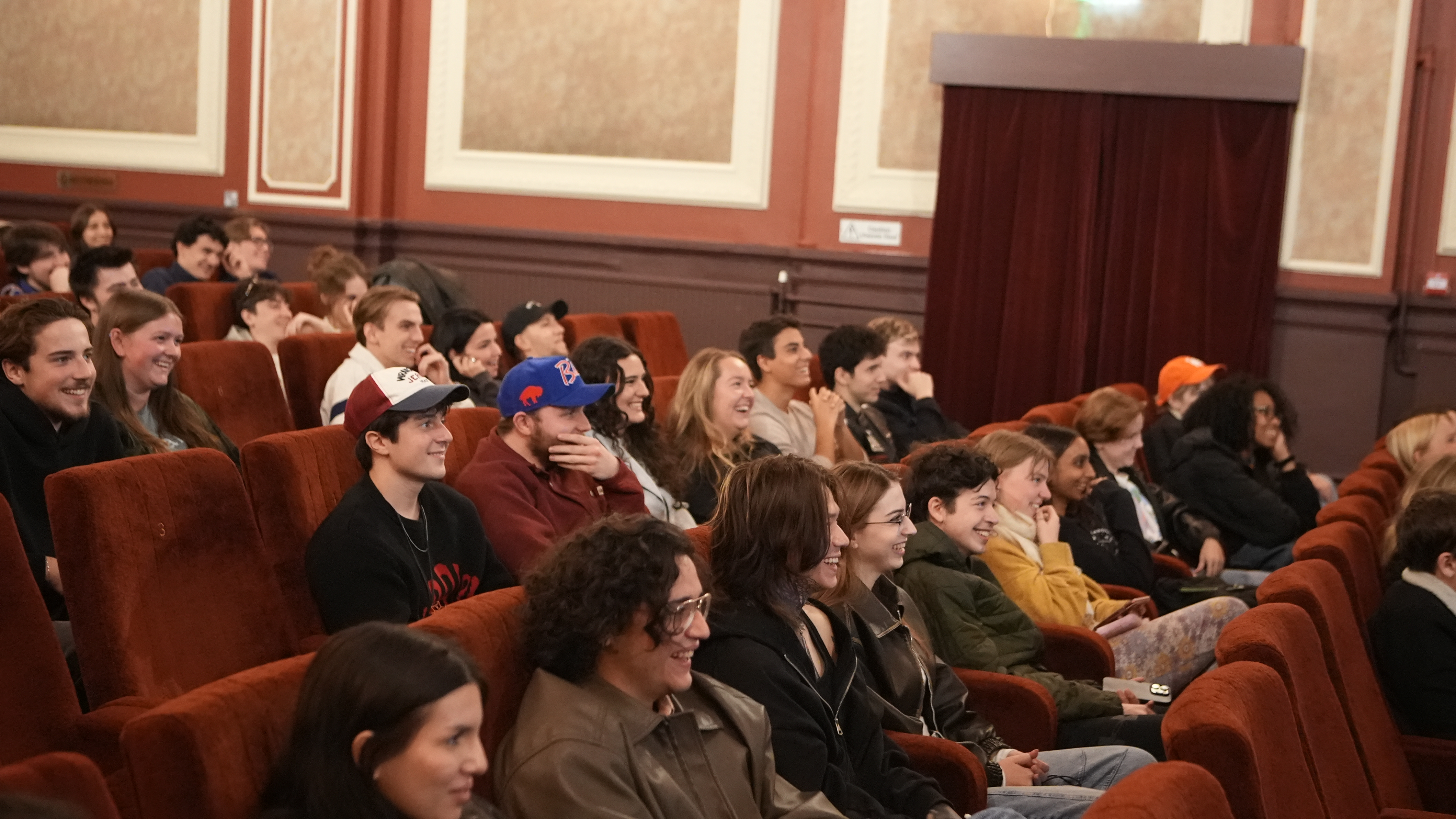 Students in cinema, seated and laughing