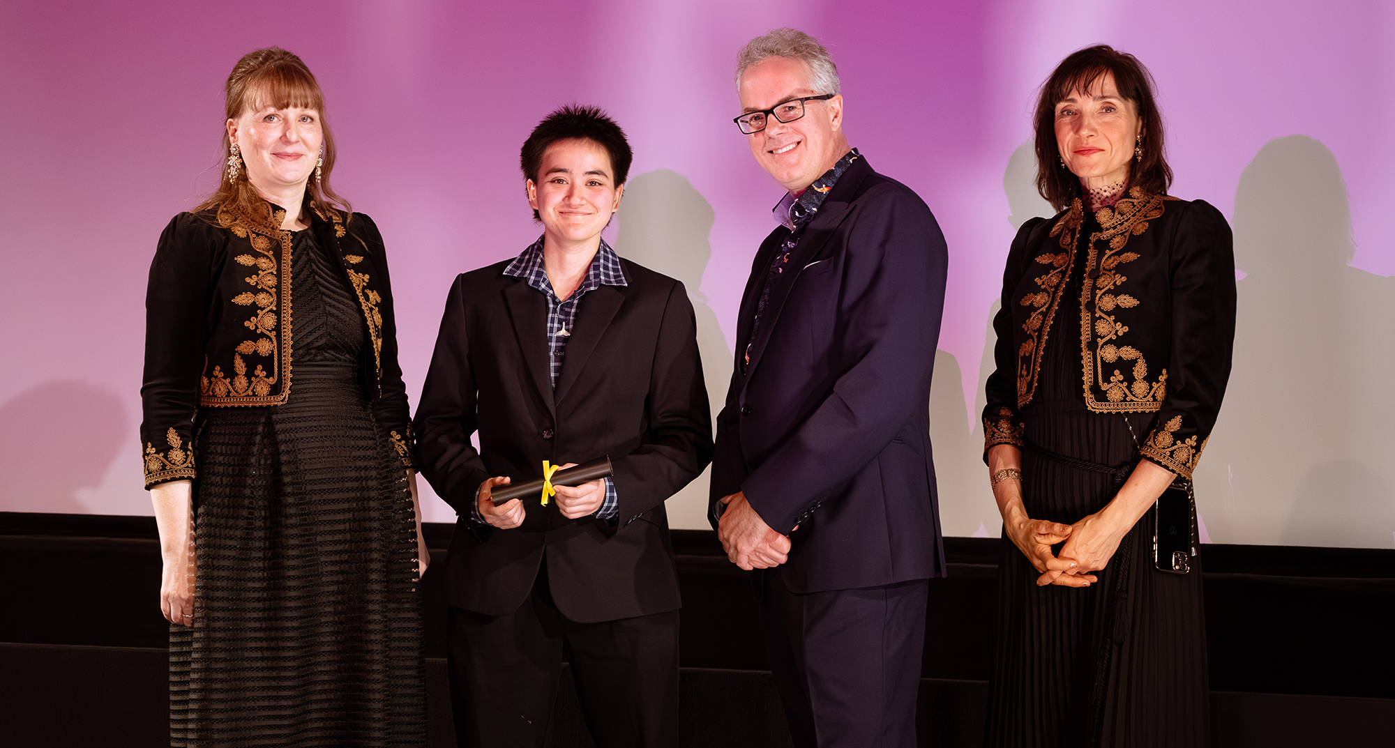 Four people onstage at the BFI, smiling at the camera