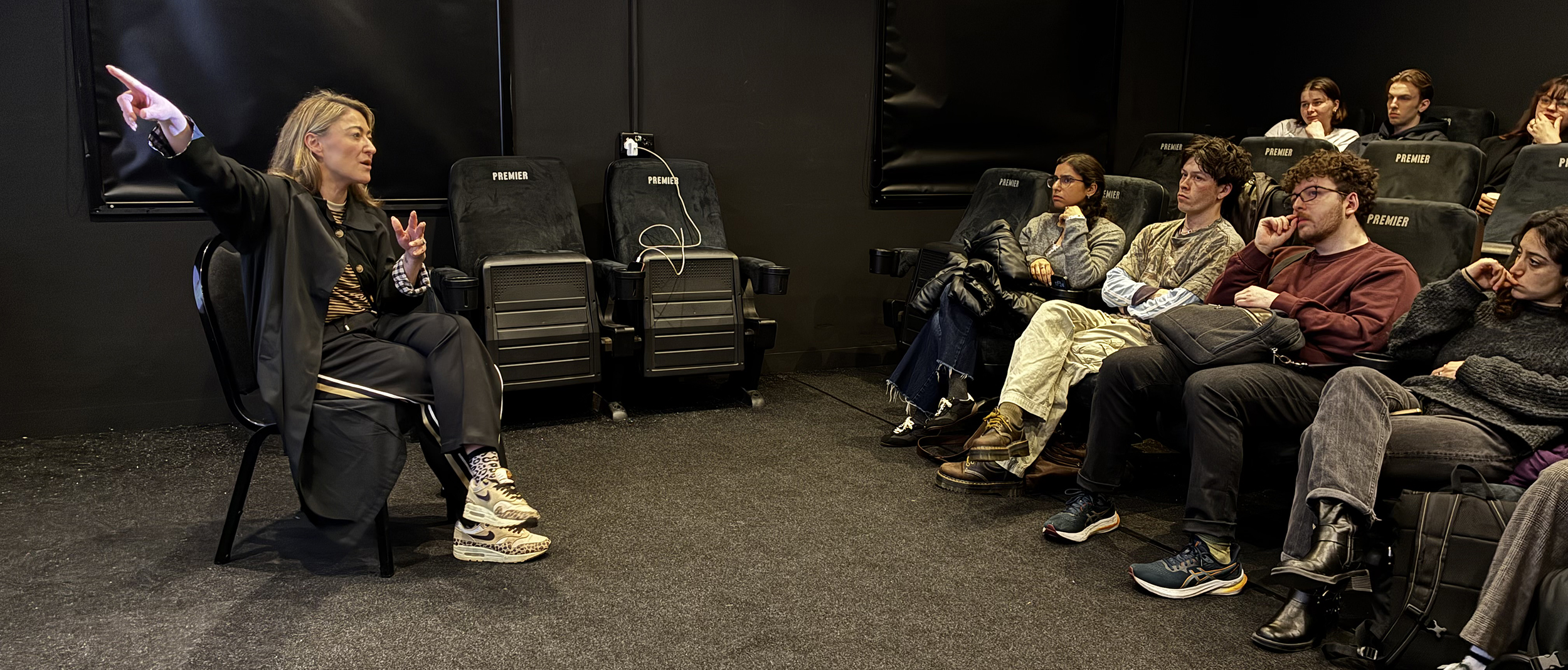 Woman talking to cinema room full of students