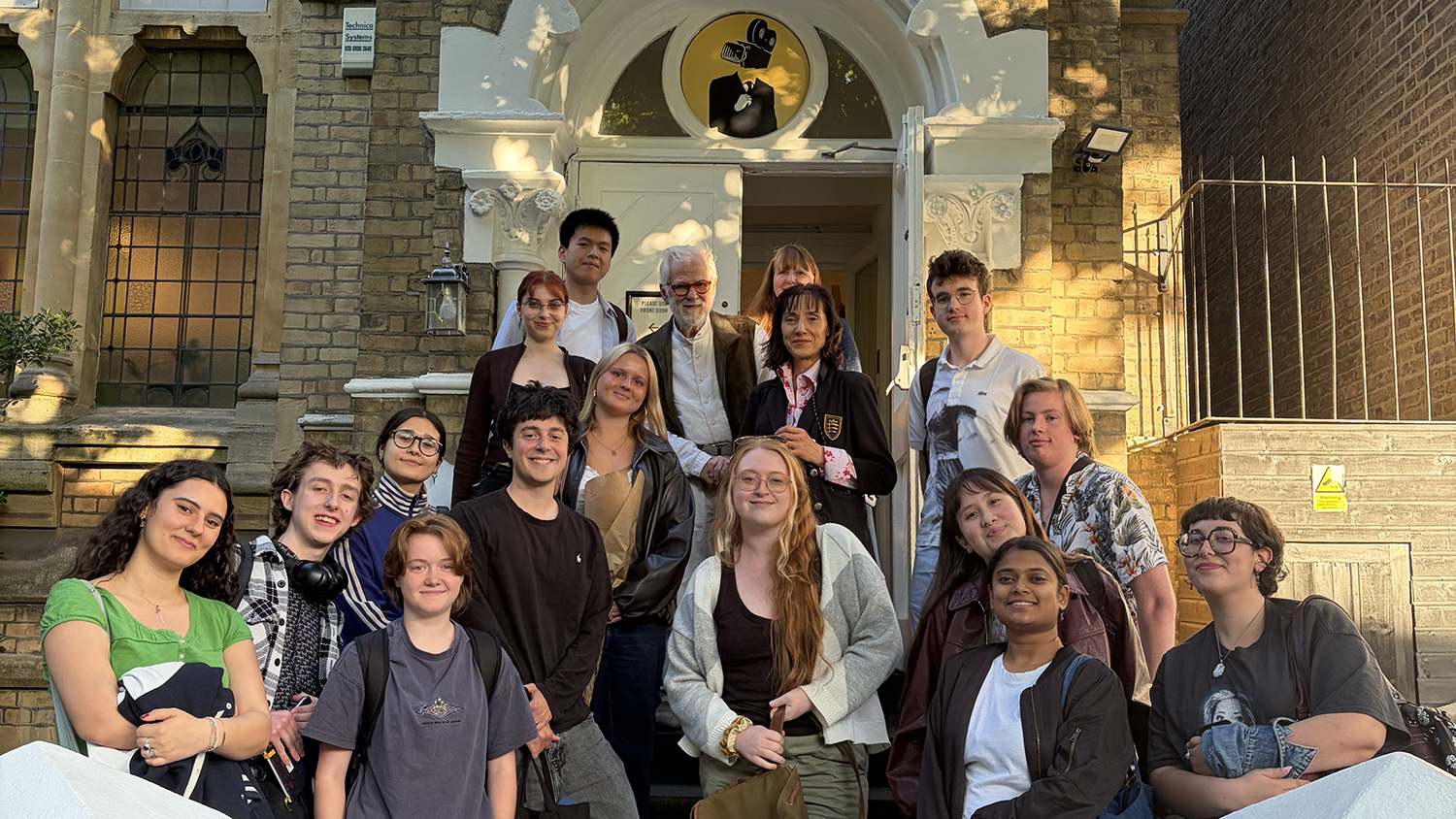 Students with filmmaker stood outside school